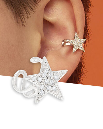 Silver star ear cuff with clear zirconia worn on middle of ear, shown on model with short brown hair and orange background.