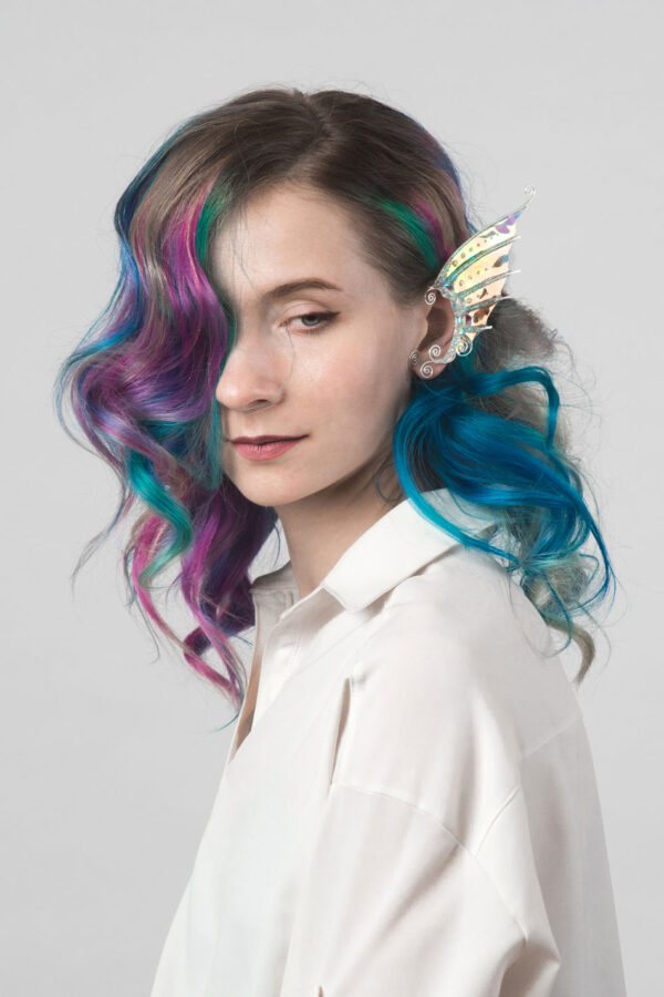 Model with multicolored hair wearing a handmade gold mermaid ear cuff with white glitter
