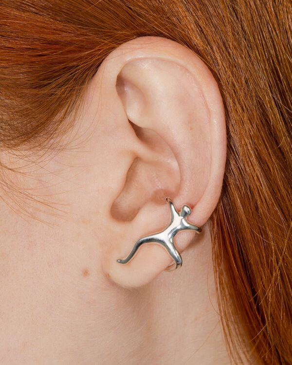 Sterling silver ear cuff shaped like a climbing man figure, worn on ear without piercing
