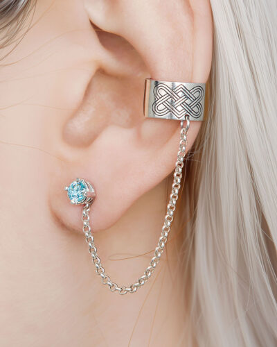 Silver Celtic chain ear cuff with blue stone stud, close-up on ear