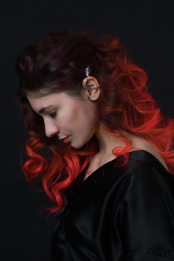 Sterling silver dragon ear cuff worn on left ear, styled with long curly red ombré hair, fantasy accessory