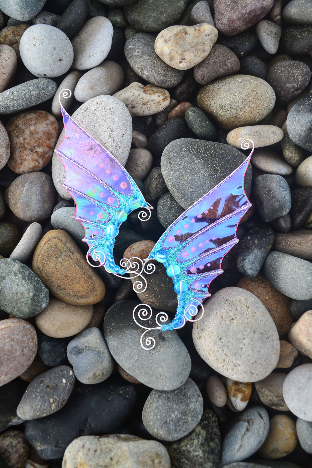 Pink and blue handmade mermaid ear cuffs on sea pebbles, no piercing needed