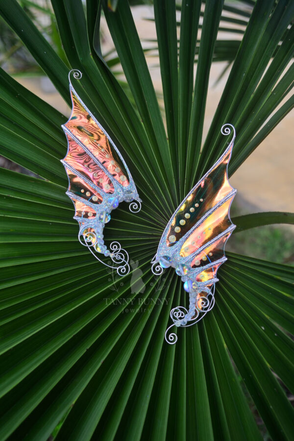 Pair of handmade gold ear cuffs with white glitter on palm leaves – fantasy mermaid design