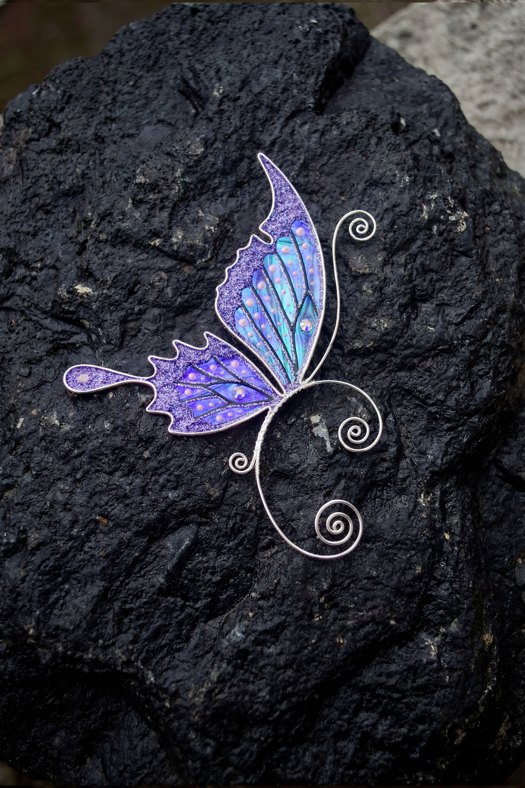 Handmade purple butterfly ear cuff on dark textured rock, fairy wing earring