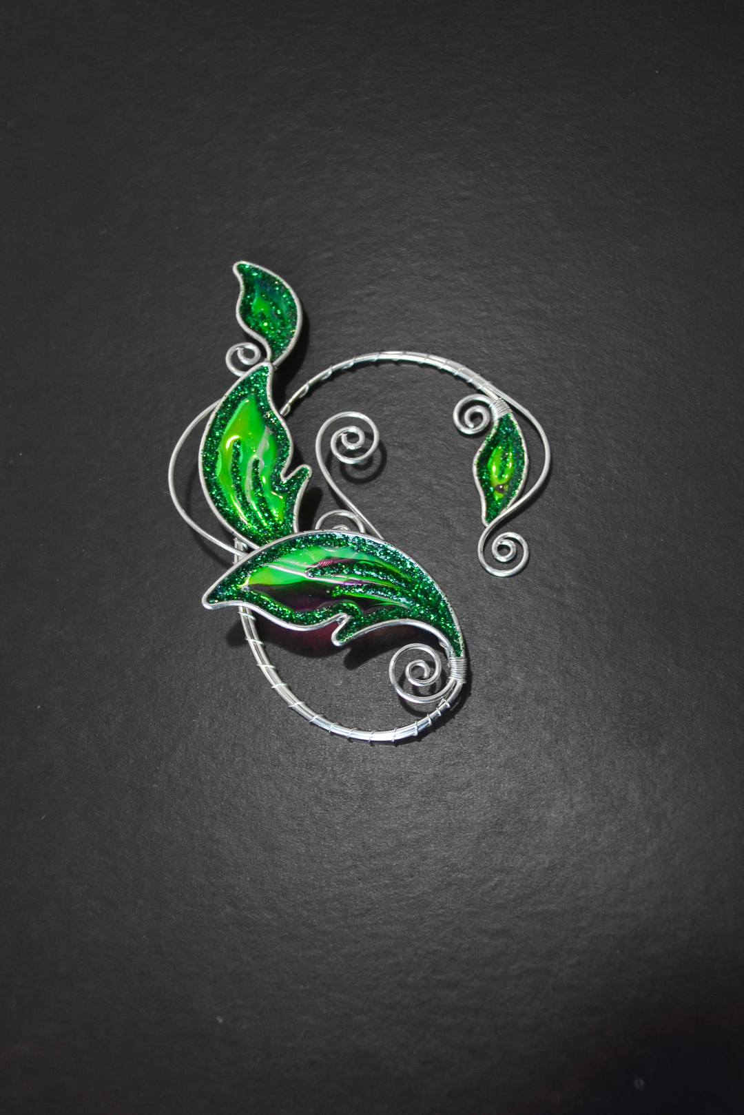 Emerald green elven leaf ear cuff on black background, handmade no-piercing fantasy ear cuff