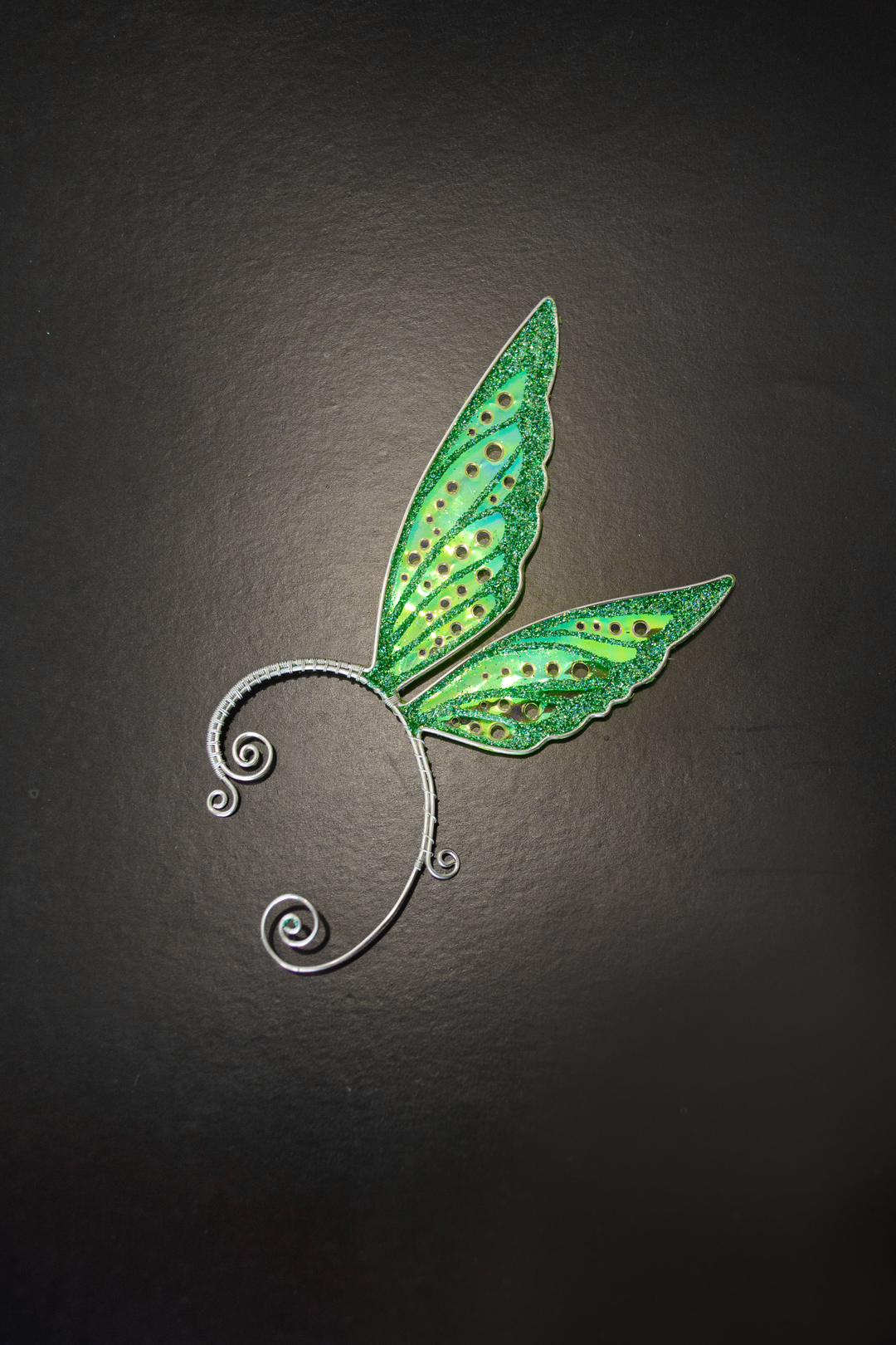 Fairy cosplay ear cuff, green, handmade, no piercing needed, fairy earring — green iridescent wing cuff on matte black background.