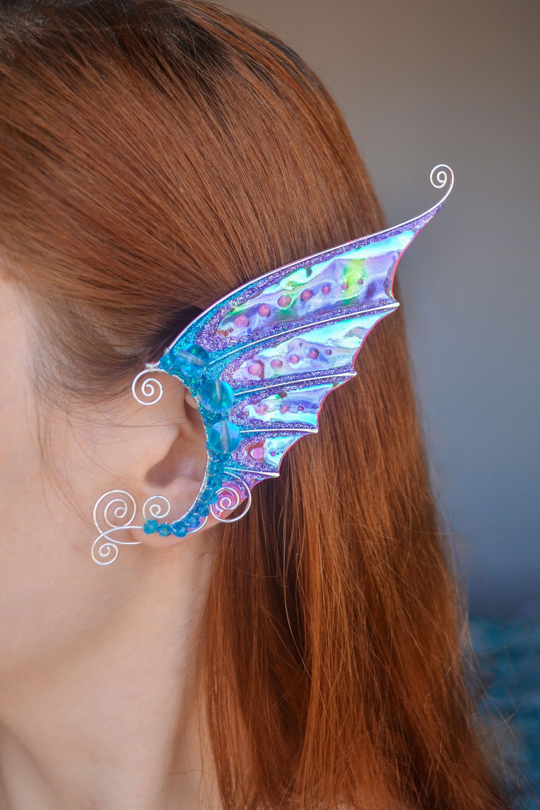 Mermaid ear cuff in pink and blue on the ear, handmade fantasy design, no piercing needed
