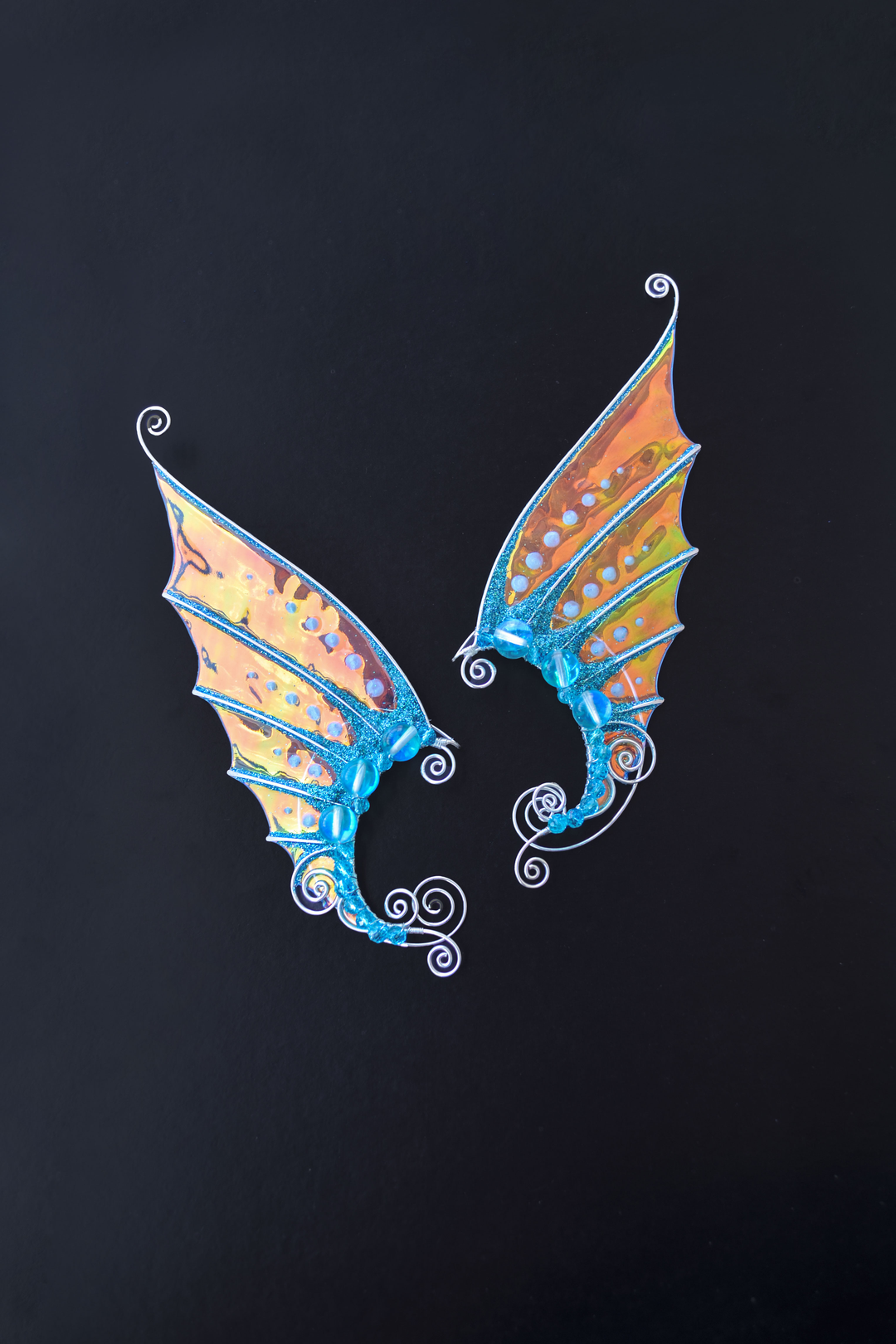 Golden and blue mermaid ear cuffs on black background, handmade fantasy cosplay earrings