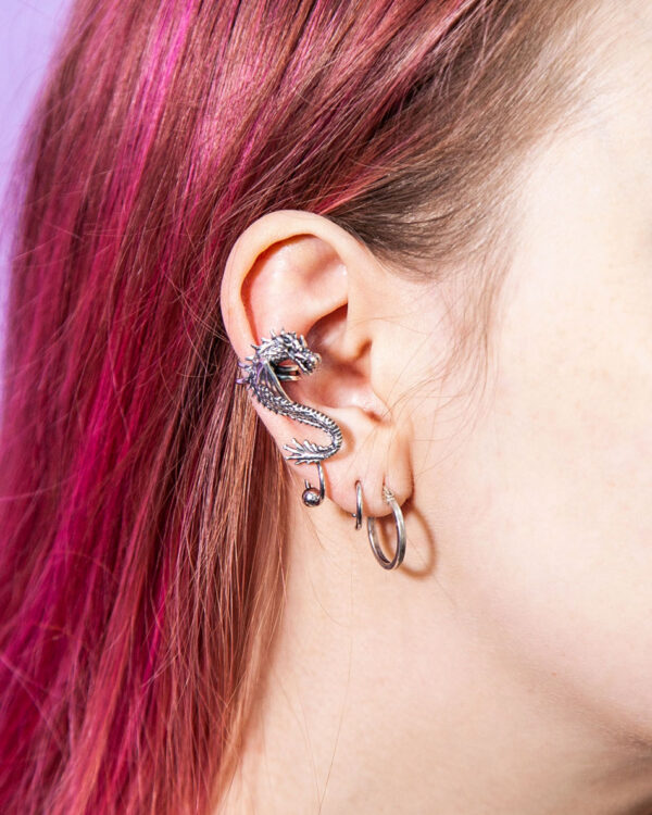 Dragon ear cuff with other earrings on a girl with pink hair