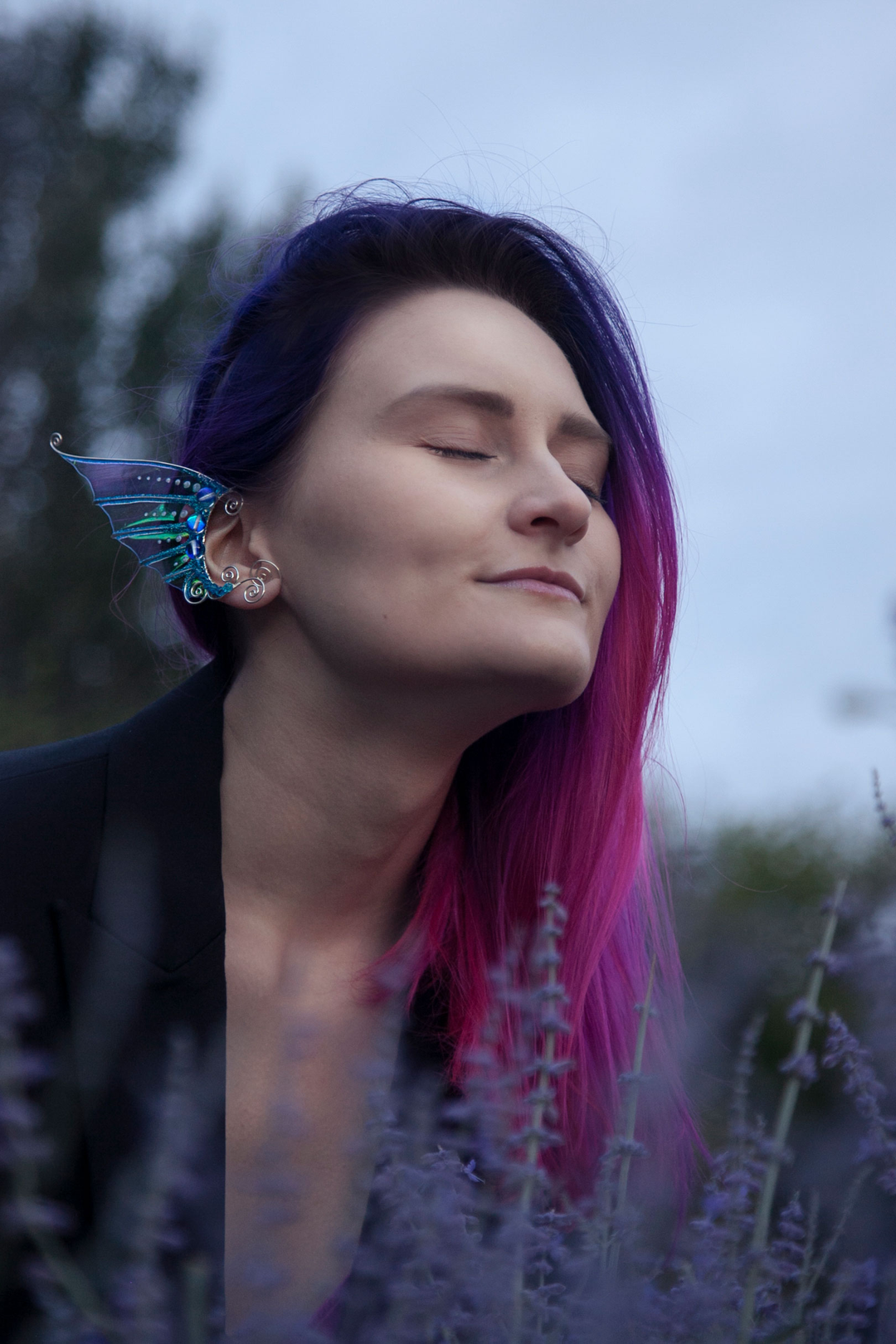 Golden and blue mermaid ear cuff worn outdoors among lavender, handmade fantasy cosplay accessory