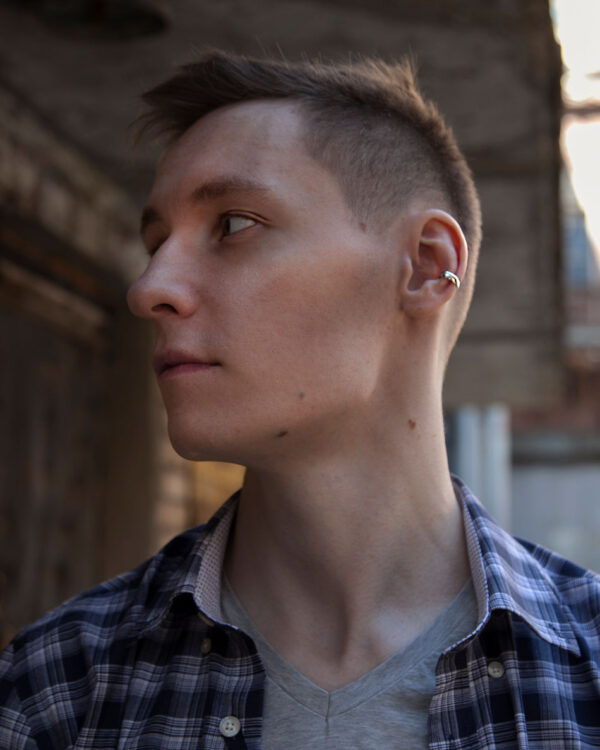 Sterling silver minimalist ear cuff worn by male model outdoors, side profile