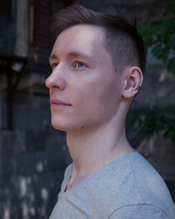 Sterling silver Dark Forest ear cuff worn by male model, outdoor side view