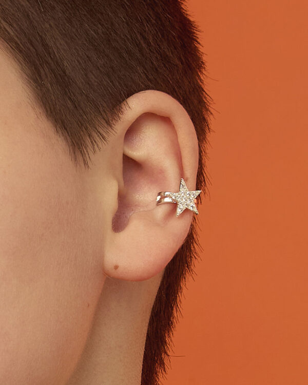 Close-up of a short-haired model wearing a silver star ear cuff with clear cubic zirconia.
