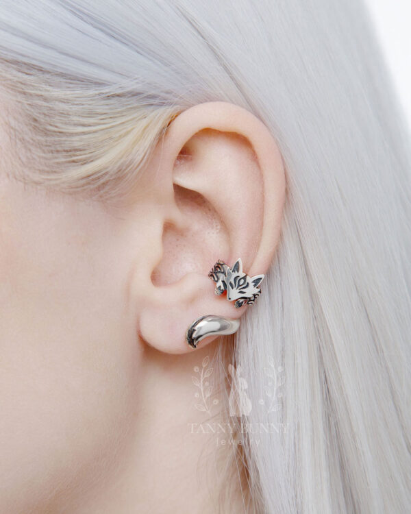 Close-up of silver fox ear cuff worn on pale ear with white hair