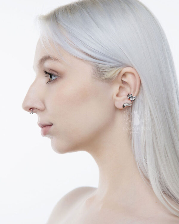 Model with white hair wearing silver fox ear cuff and nose ring