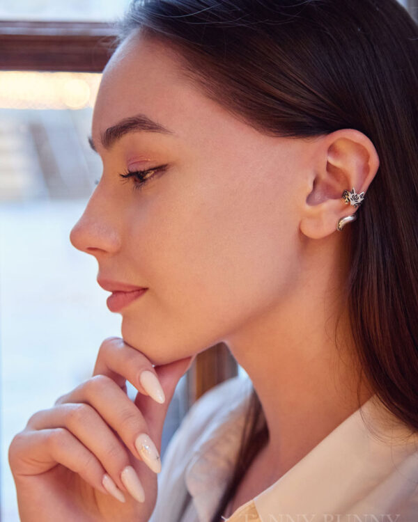 Young woman wearing silver fox ear cuff, resting her chin on hand