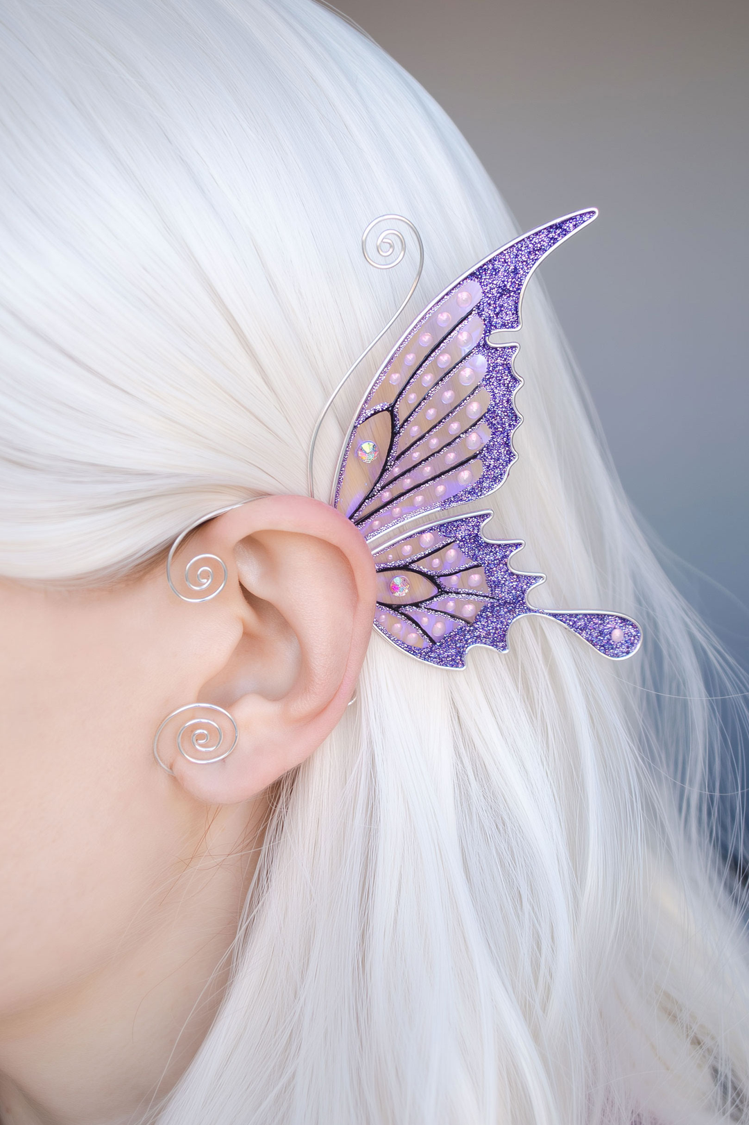 Purple butterfly ear cuff worn on white-haired model, handmade fairy wing earring