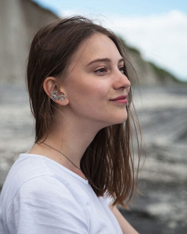 Girl wearing a silver dragon ear cuff on the beach