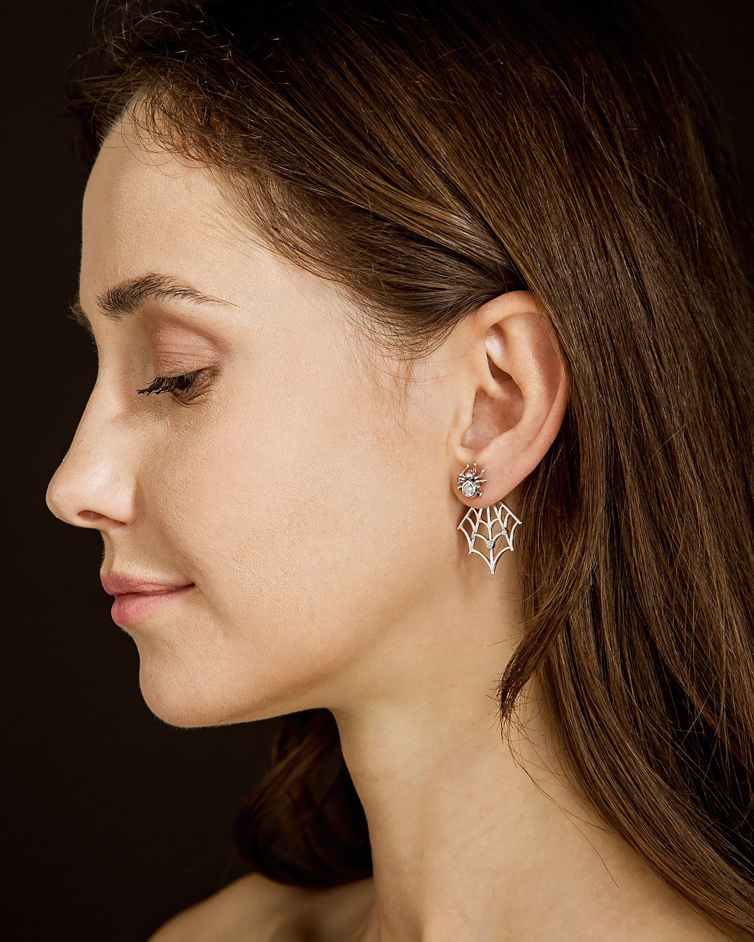 profile view of woman wearing spider web ear jacket earrings