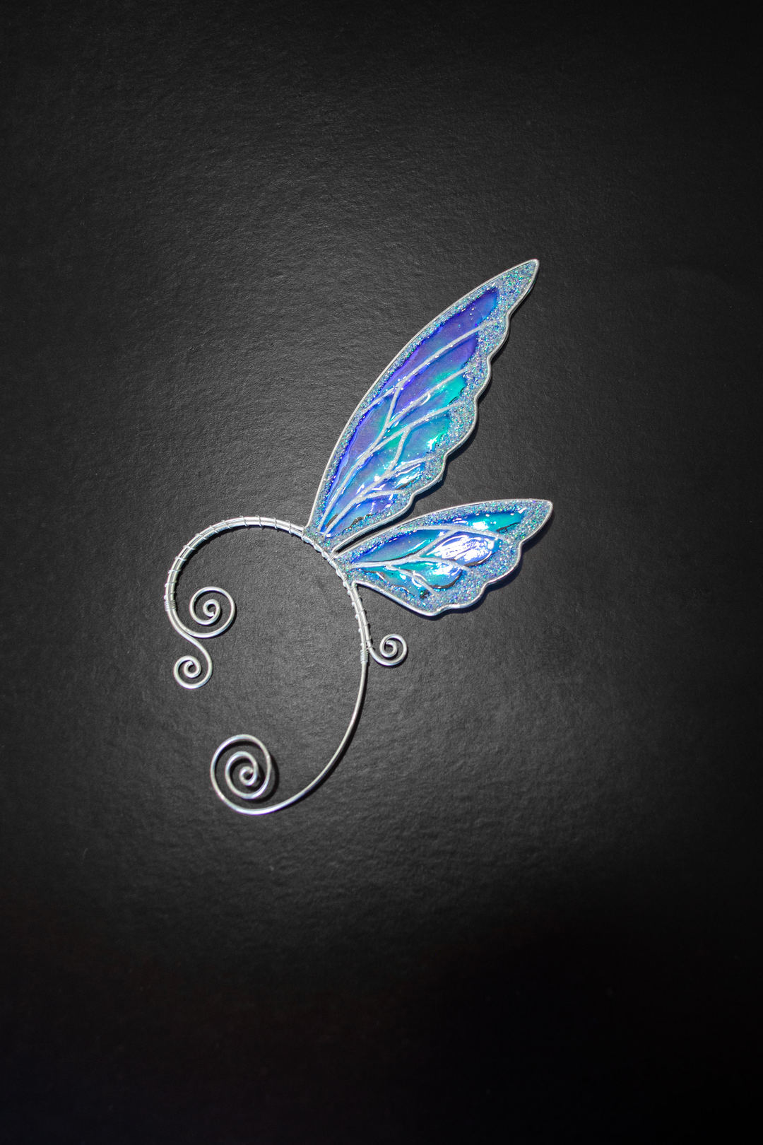 fairy wing ear cuff in white iridescent holographic design on black background