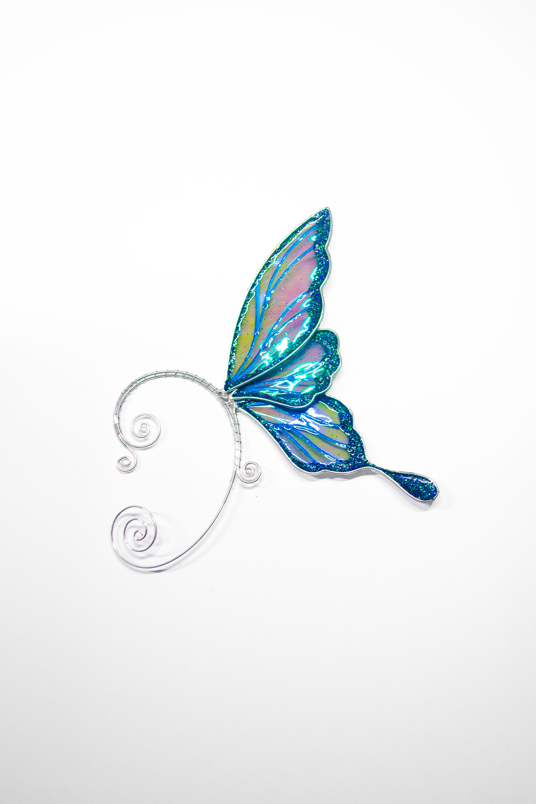Iridescent blue fairy wing ear cuff on white background, handmade