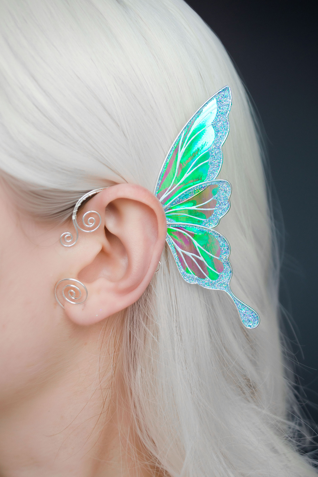 iridescent fairy wing ear cuff in green and white worn on ear, no-piercing fairy cosplay jewelry