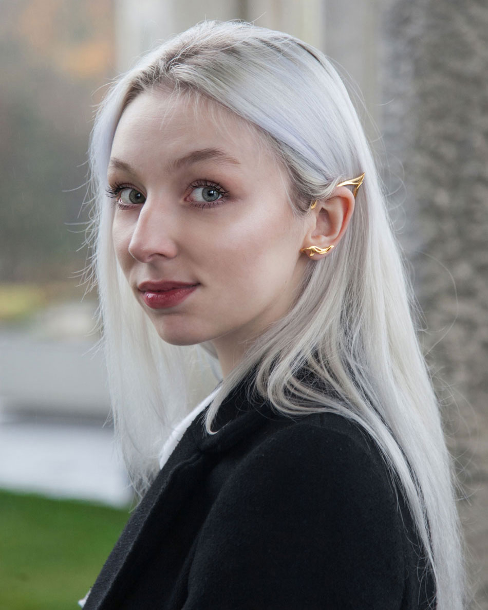Model wearing gold elf ear cuff outdoors