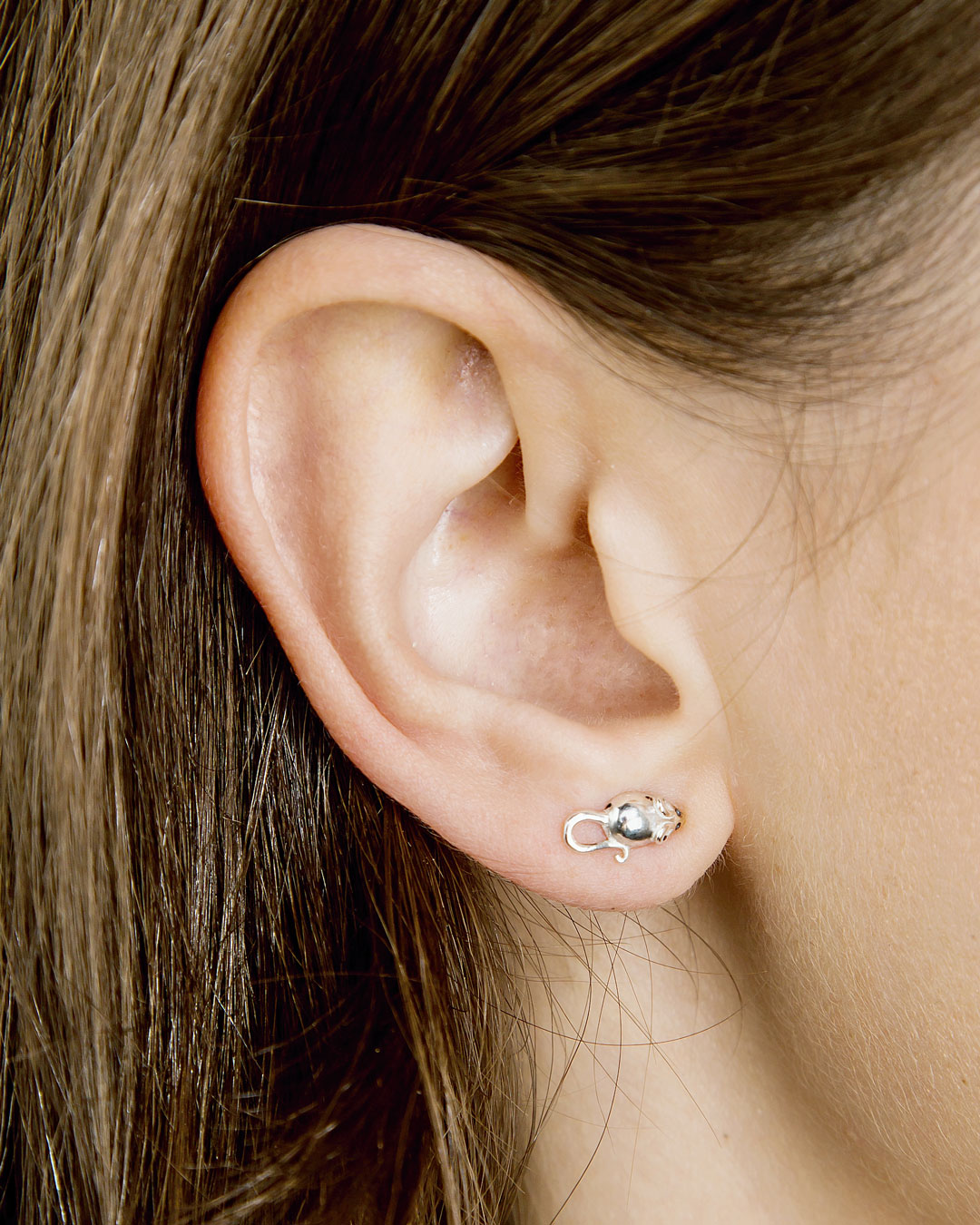 Silver mouse stud earring on model’s earlobe