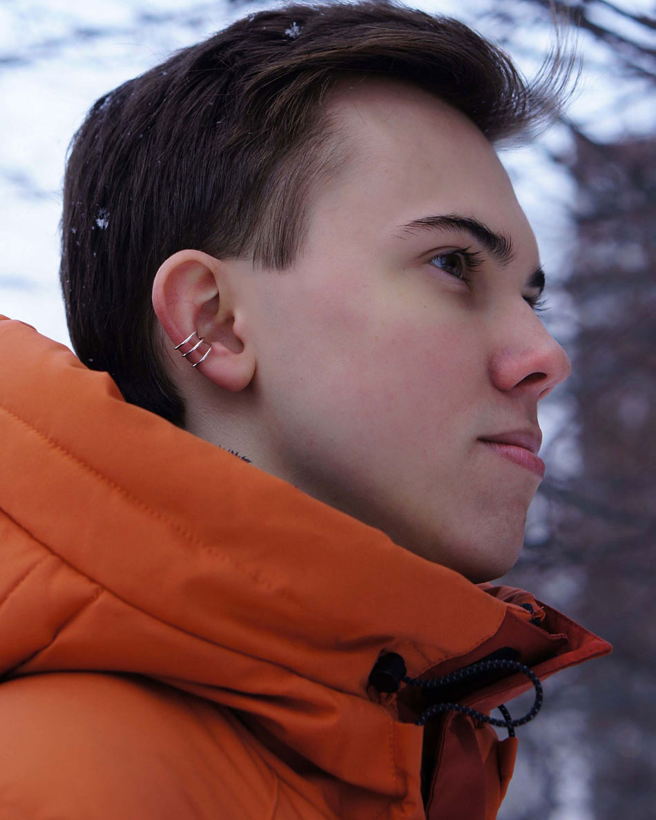 Close-up of silver 3 rings ear cuff on man’s ear