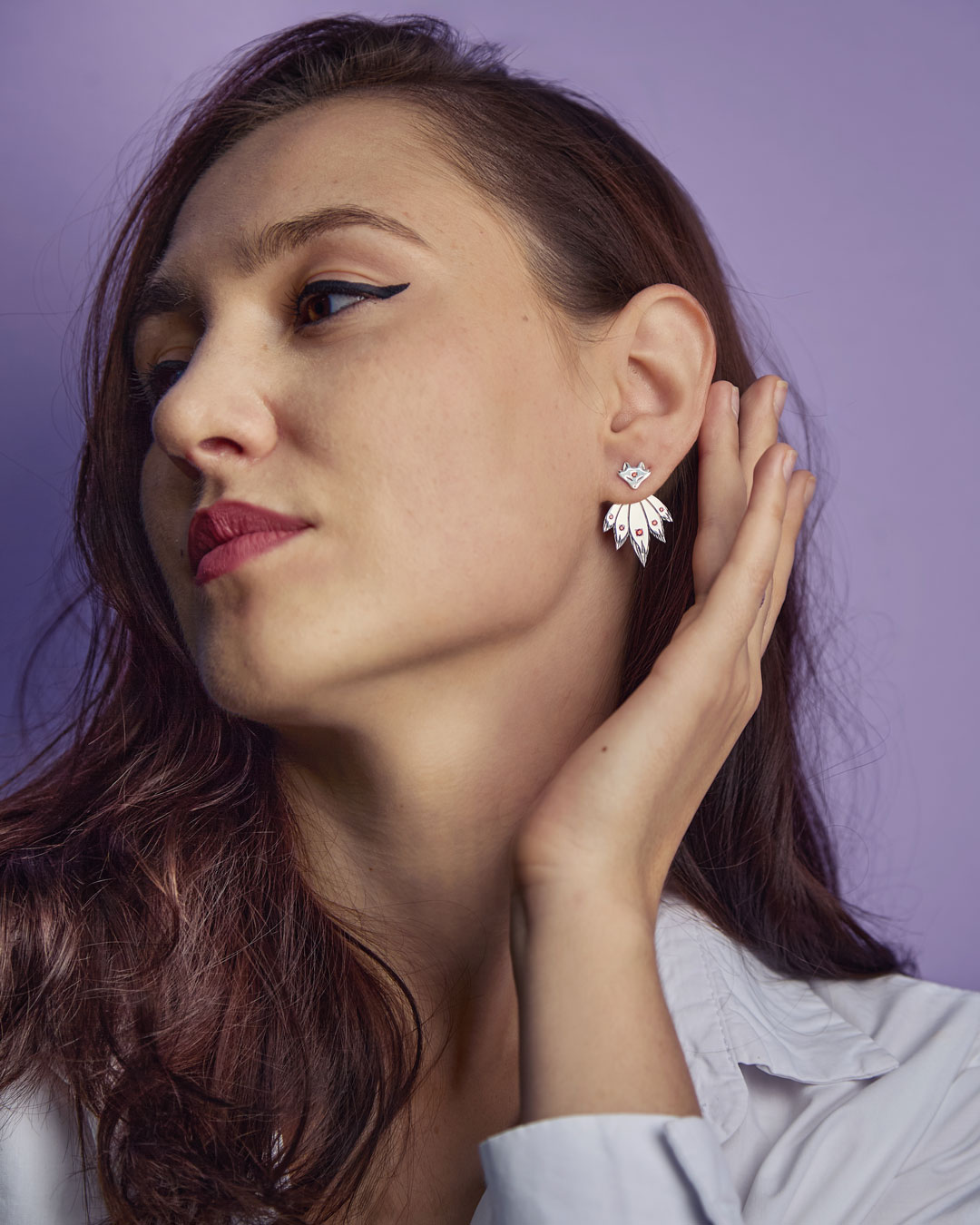Fox ear jacket earrings worn by model against purple background