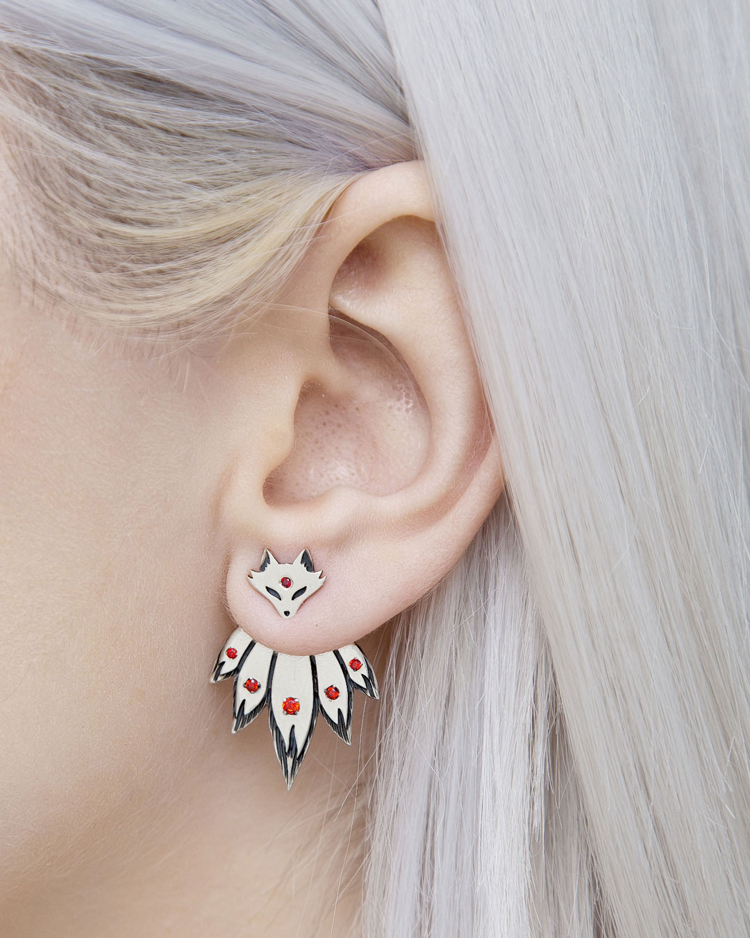 Detailed close-up of fox ear jacket earrings with red stones