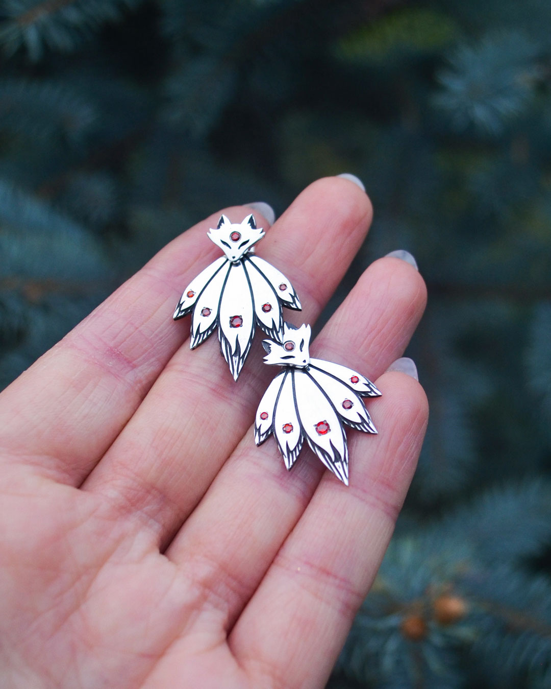 Fox ear jacket earrings displayed in hand