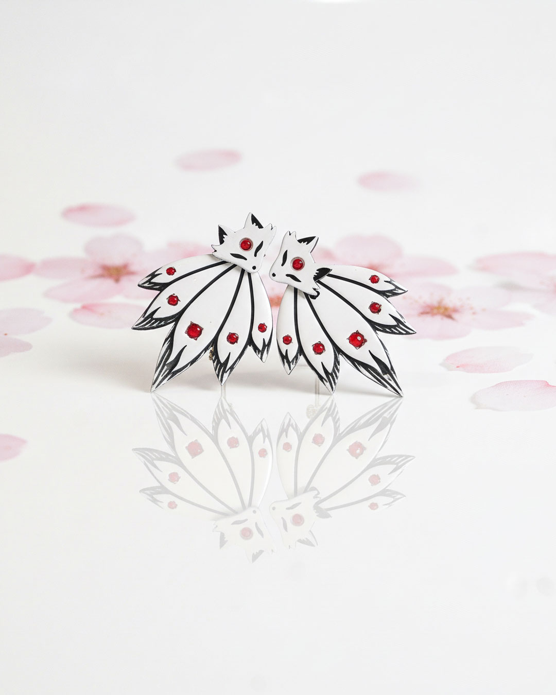 Fox ear jacket earrings on reflective surface