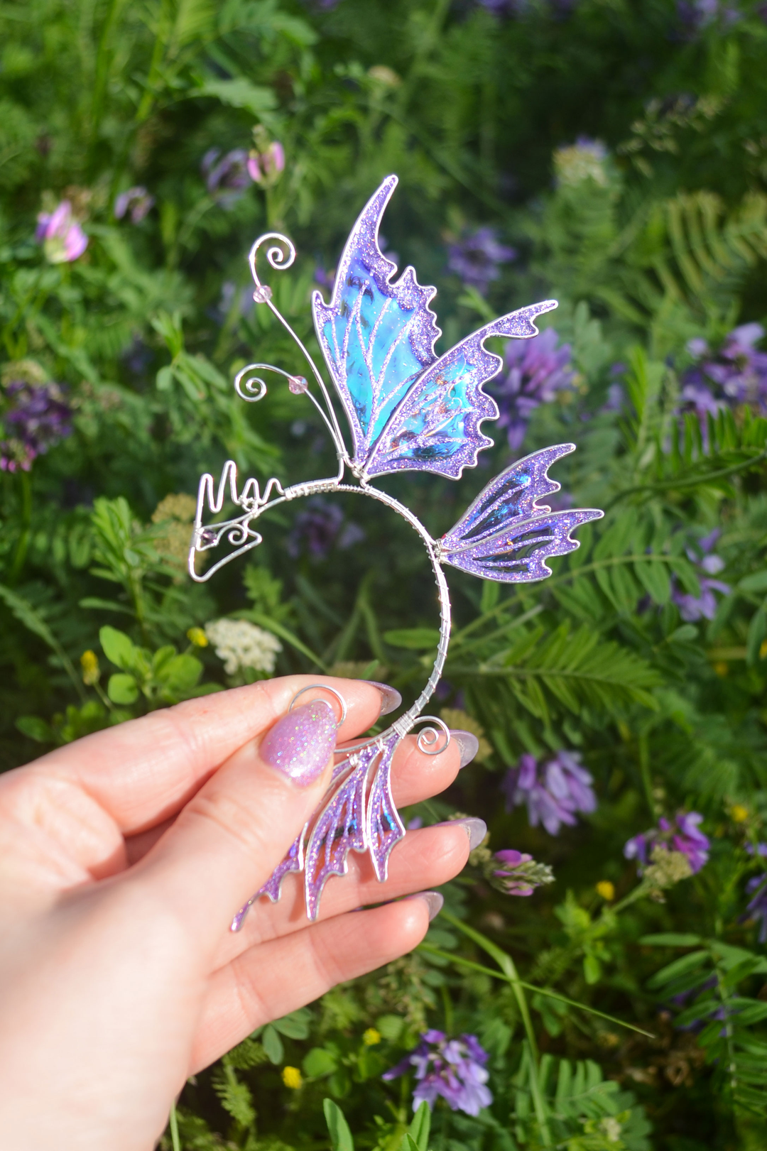 fairy dragon ear cuff held in hand, handmade fantasy ear cuff with dragon wing design, no piercing needed