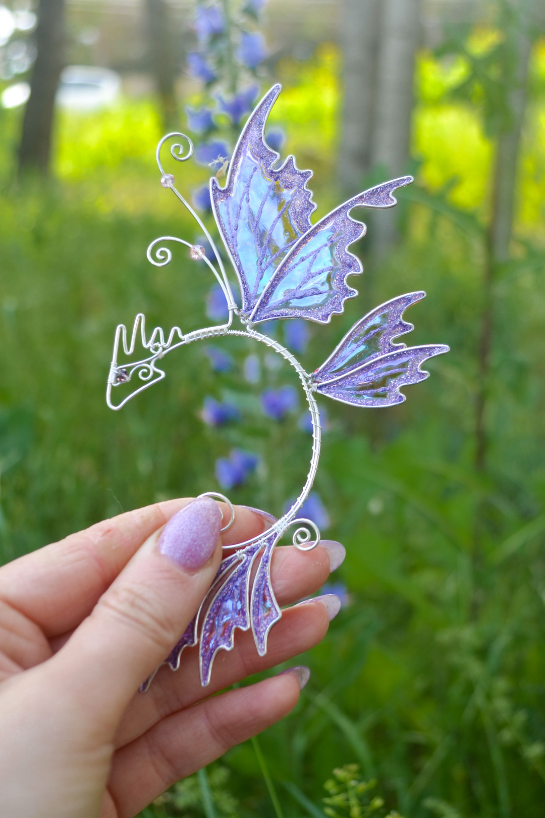 fairy dragon ear cuff held in hand outdoors, handmade fairy cosplay earrings