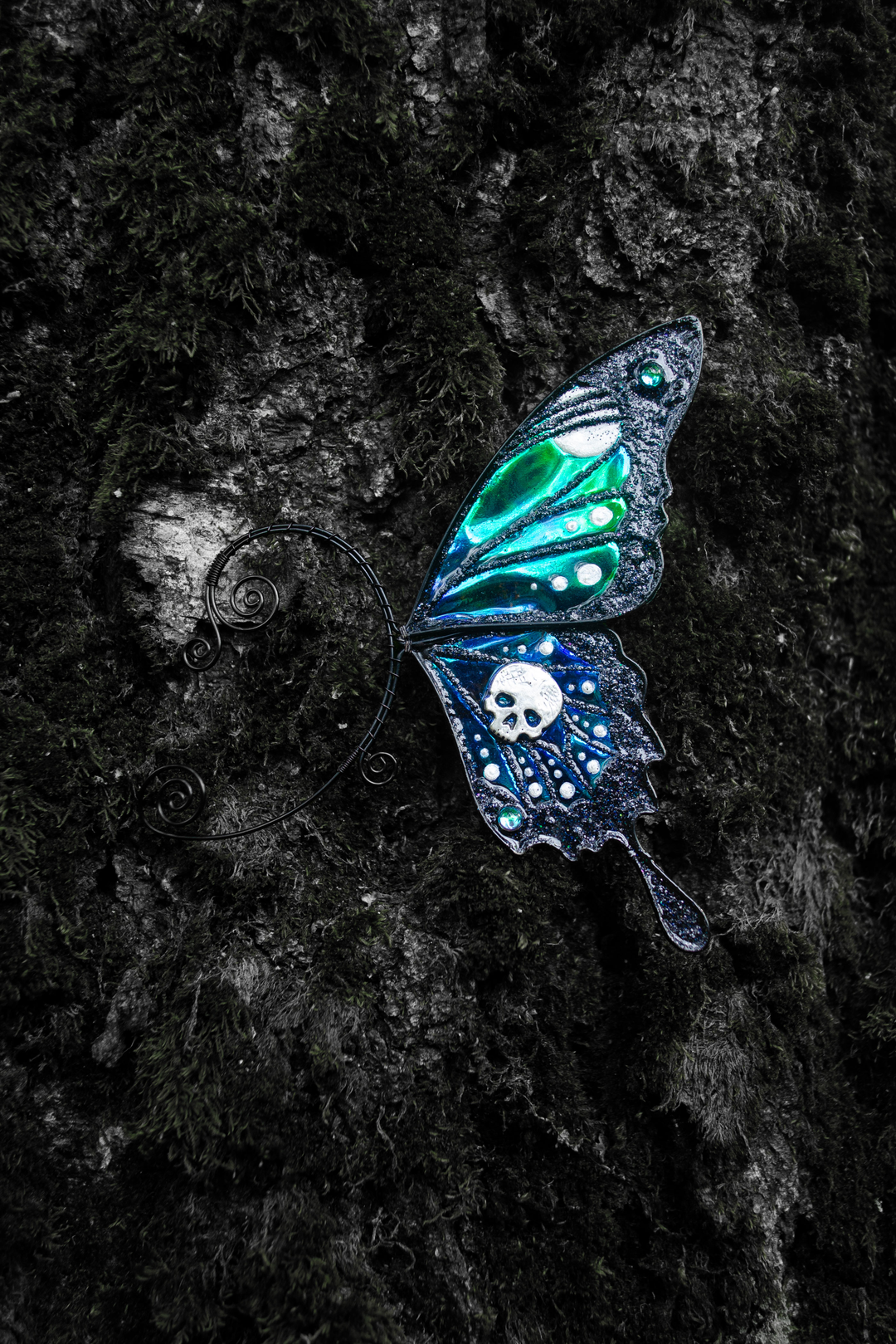 Gothic butterfly ear cuff with skull on dark tree bark
