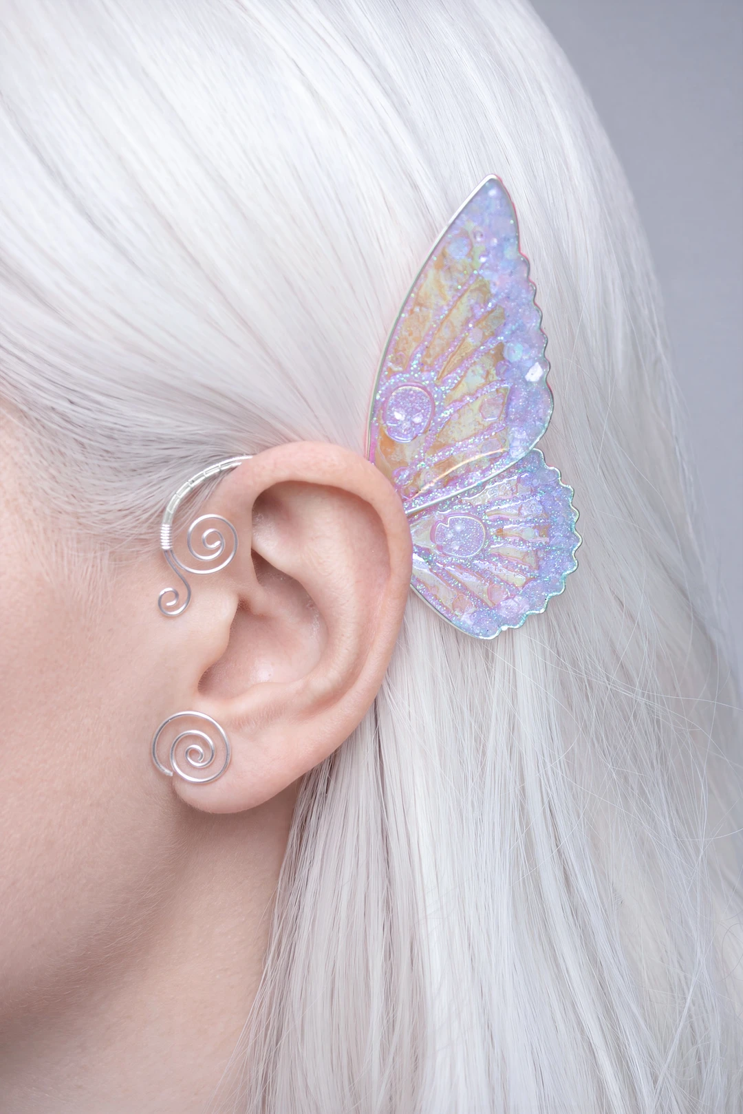 Blue butterfly ear cuff with skull worn with white hair